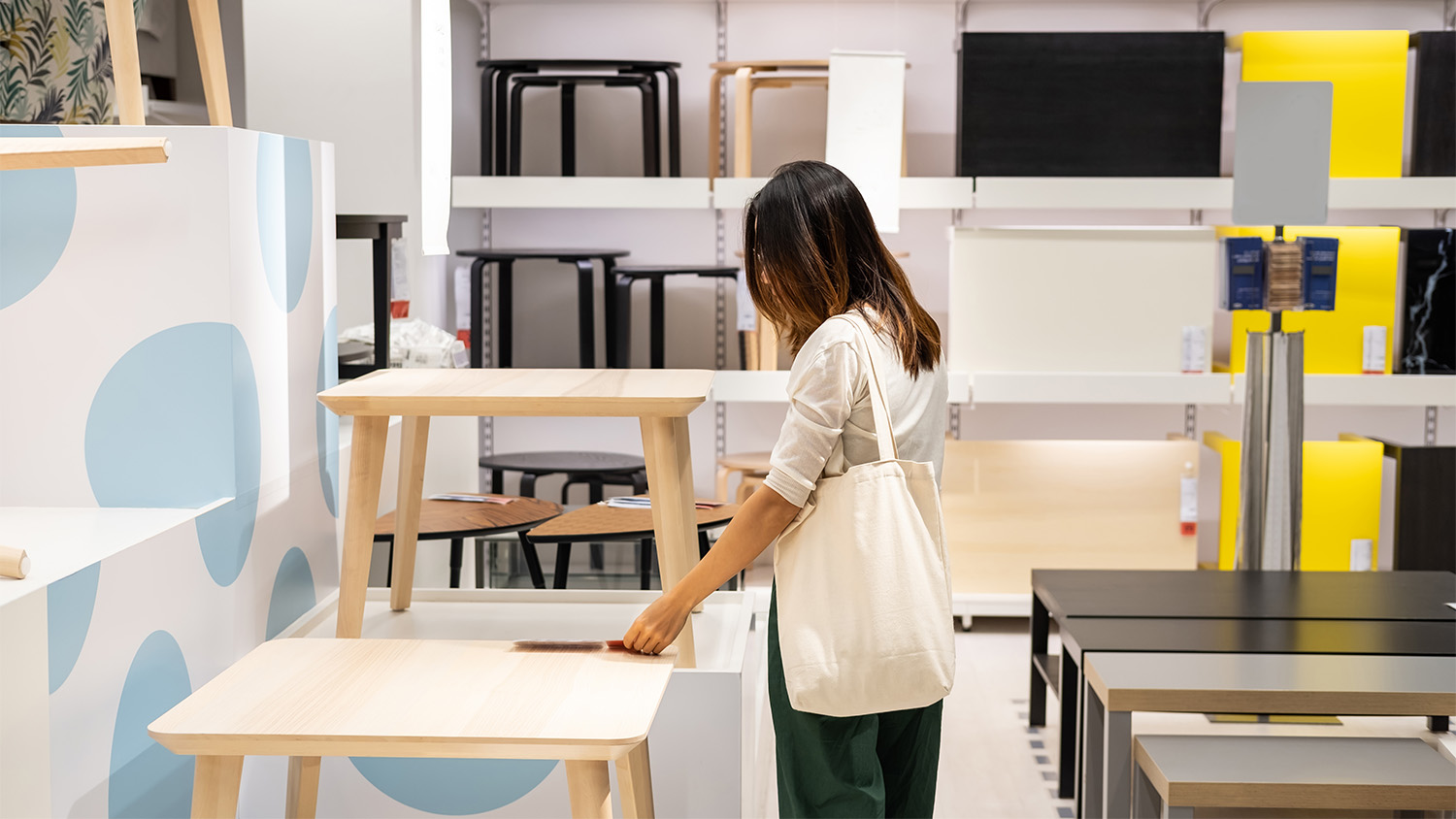 woman in furniture store looking at tables 