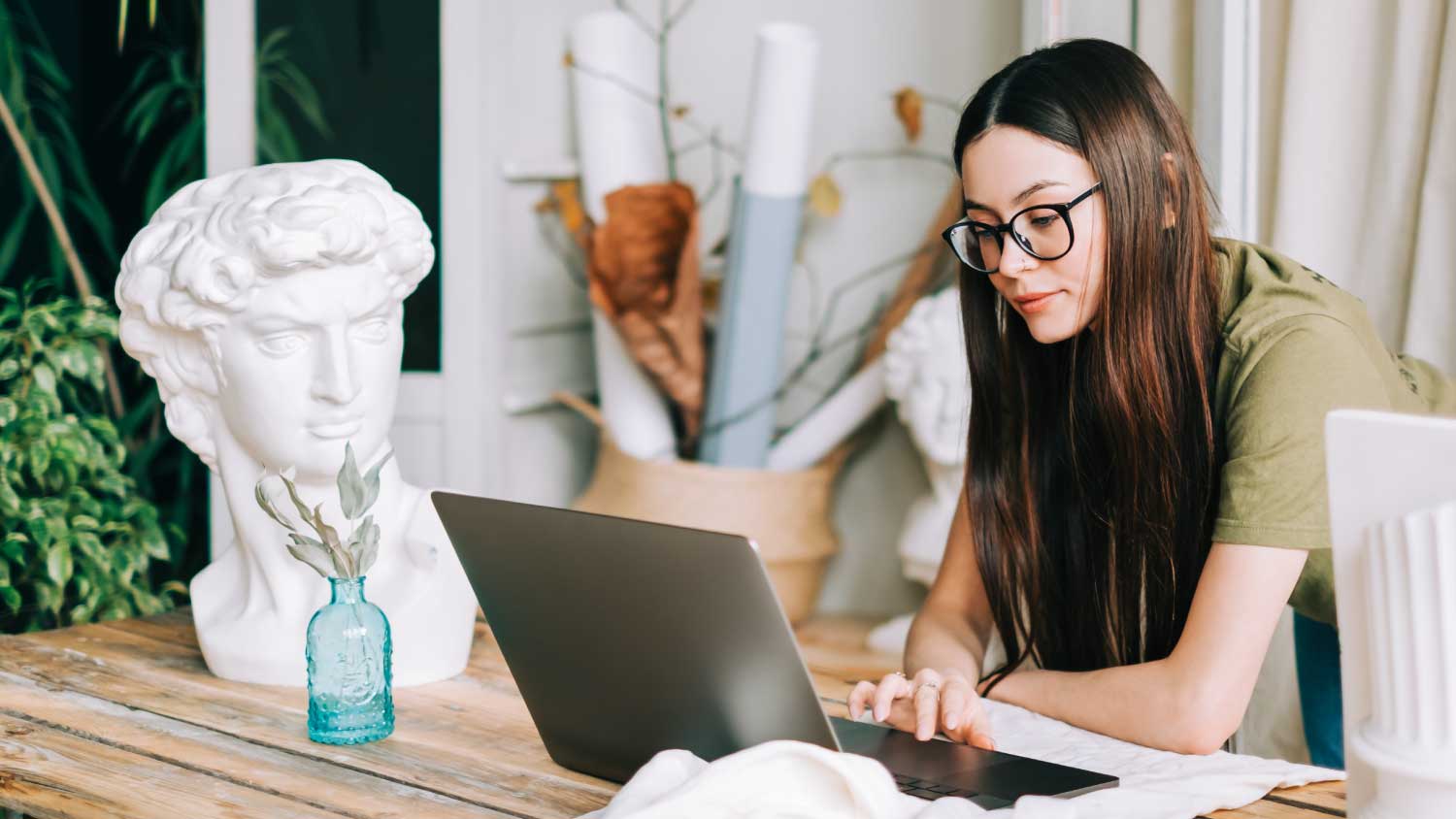 young woman on laptop near sculpture