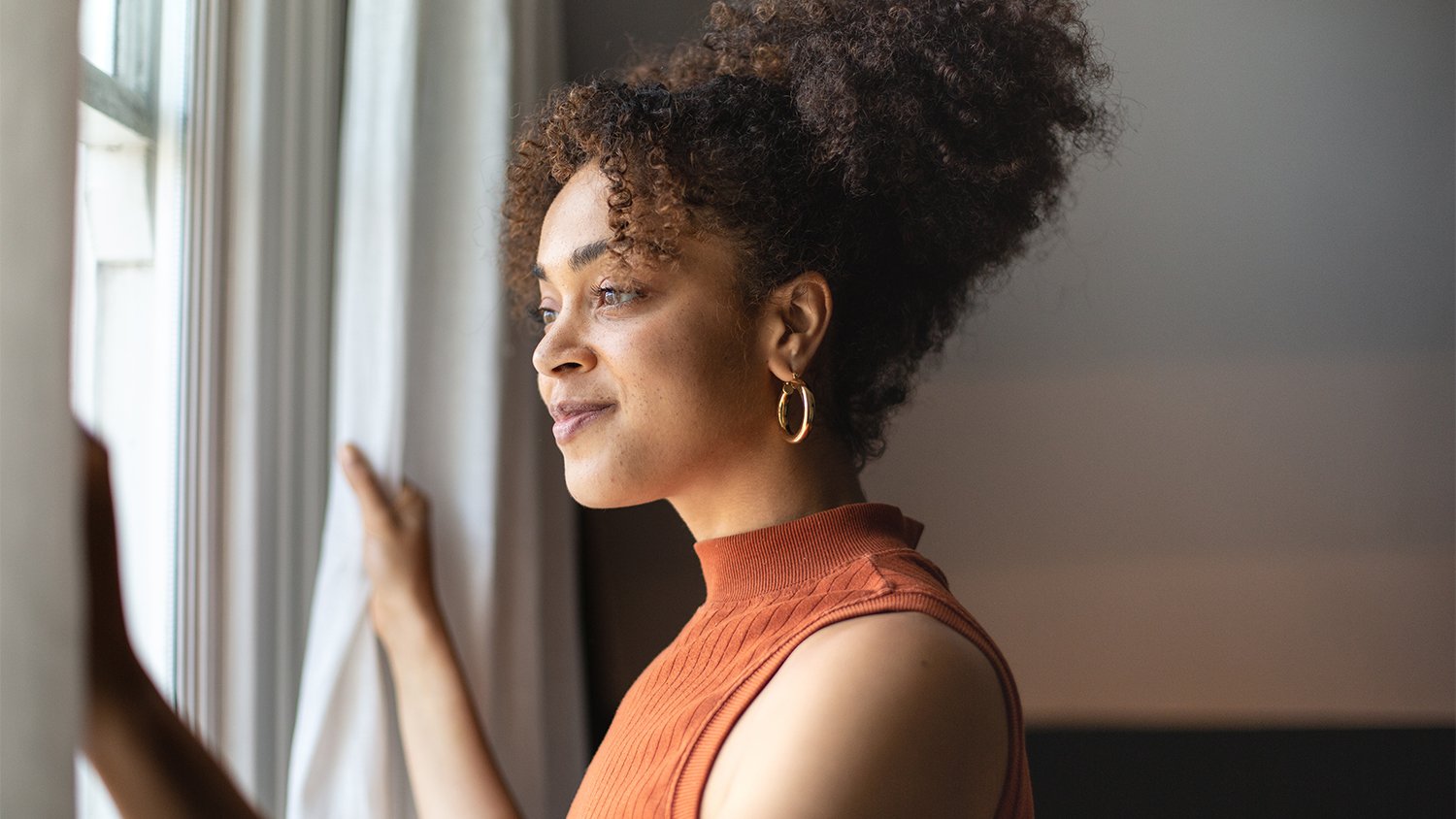 woman looking out of the window from home