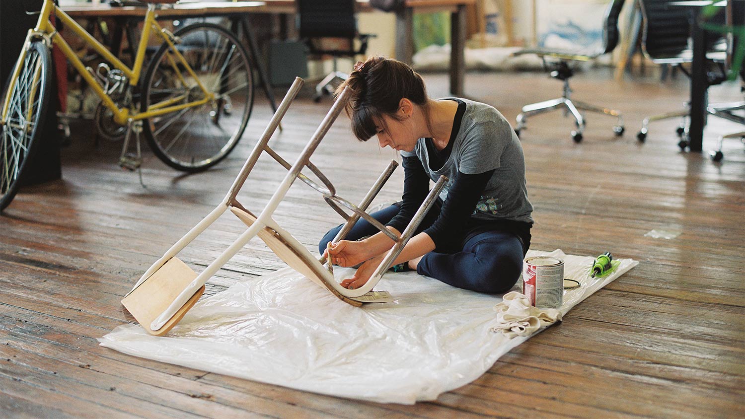 Woman on floor painting chair