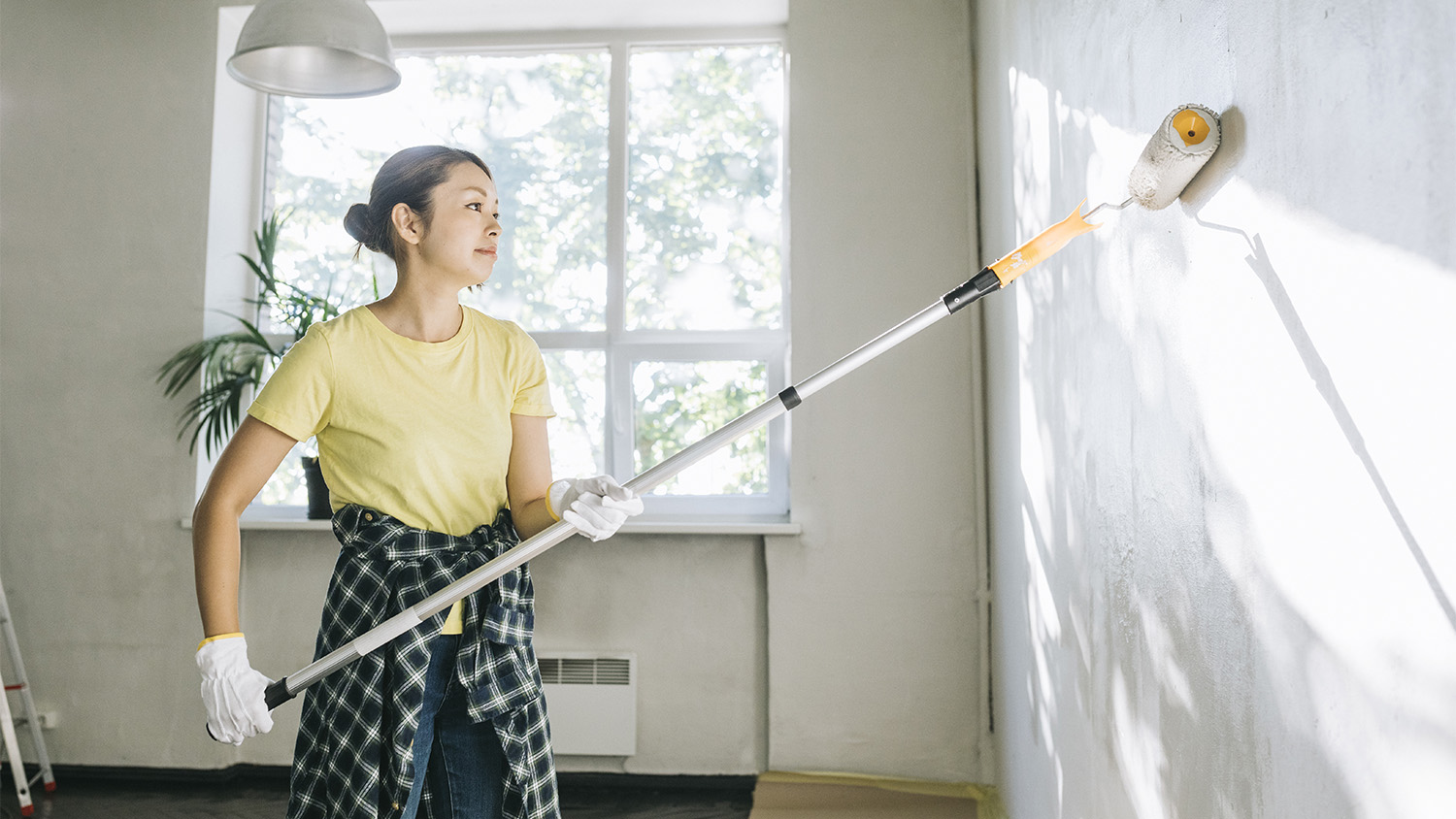  woman painting walls of her home white