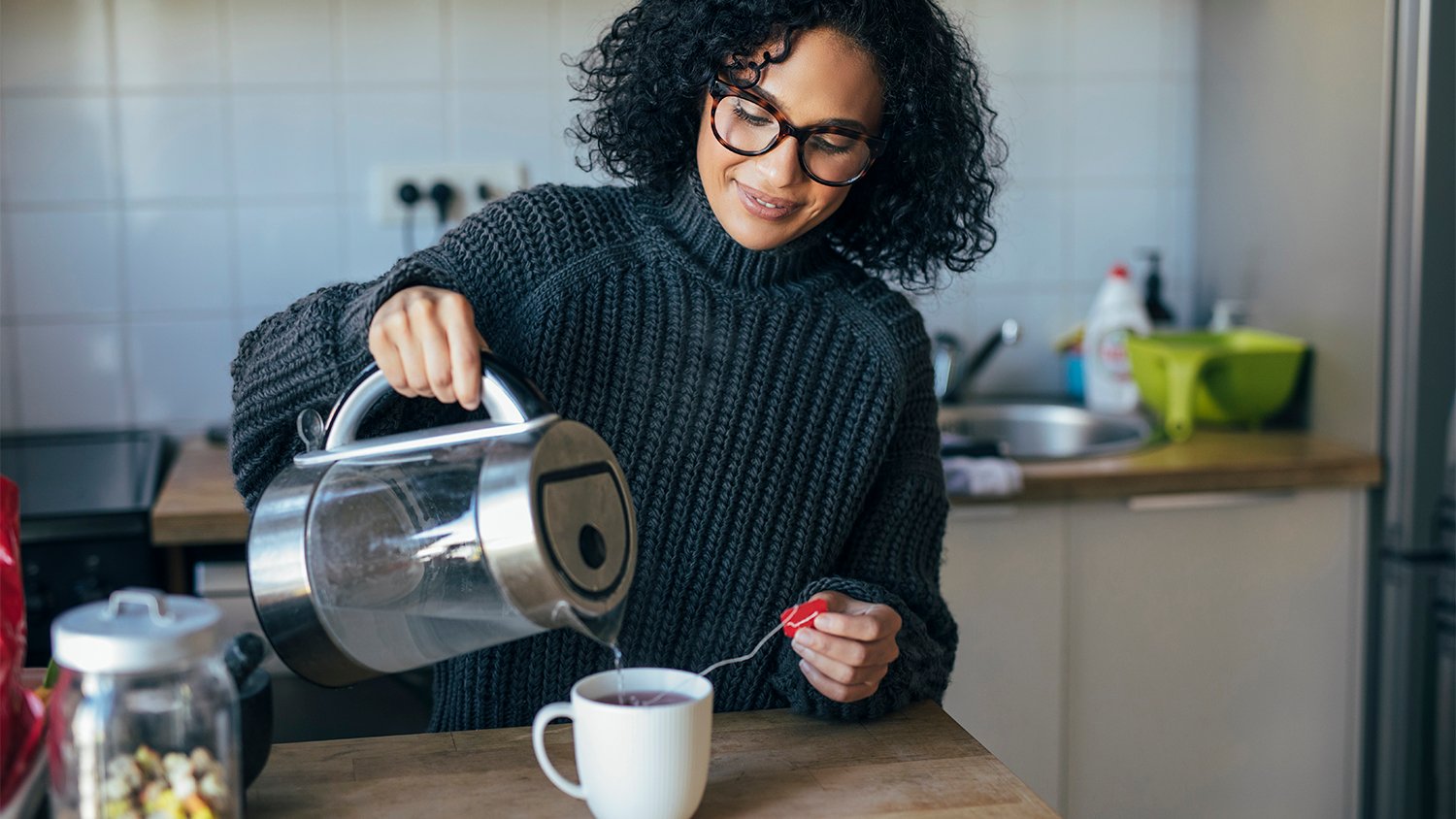 Woman pours herself a hot tea on a cold day