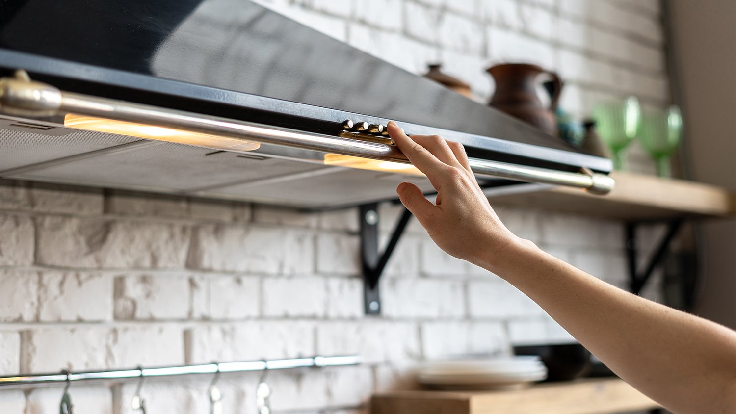 woman turning on range hood vent