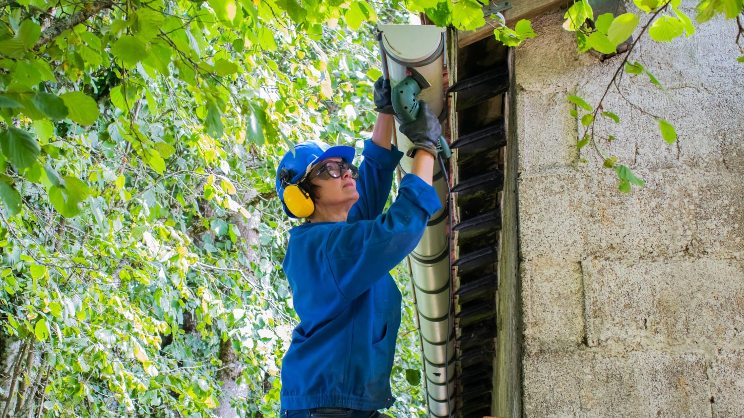 Woman working on replacing the roof drain pipes