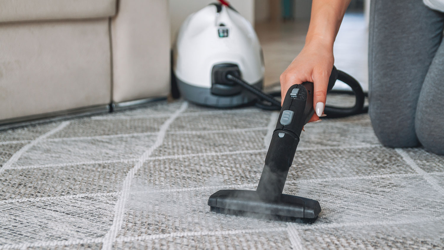 A woman steam cleaning a carpet