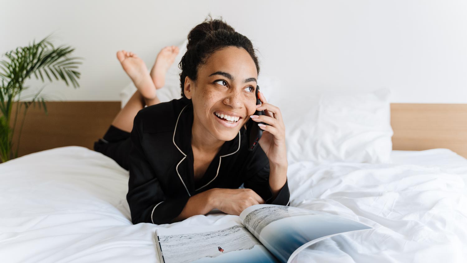 Woman talking on cellphone and reading magazine