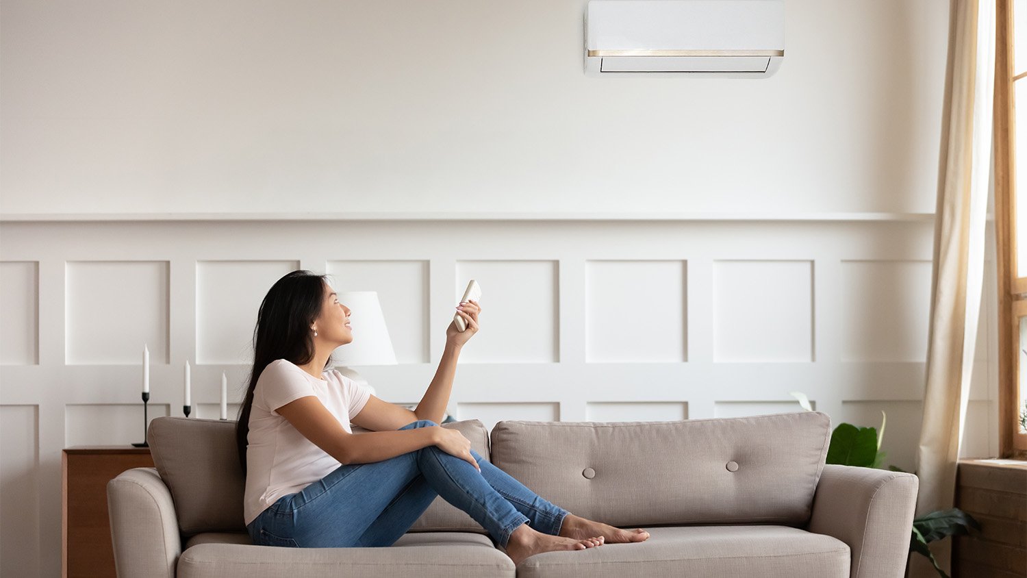 woman on couch turning off ac