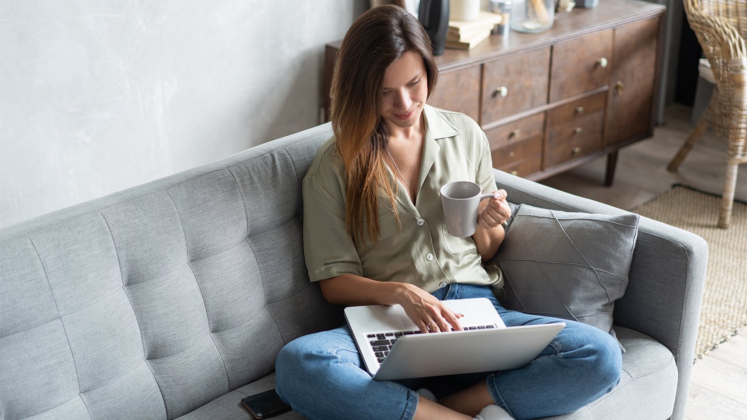 woman working on laptop from couch  