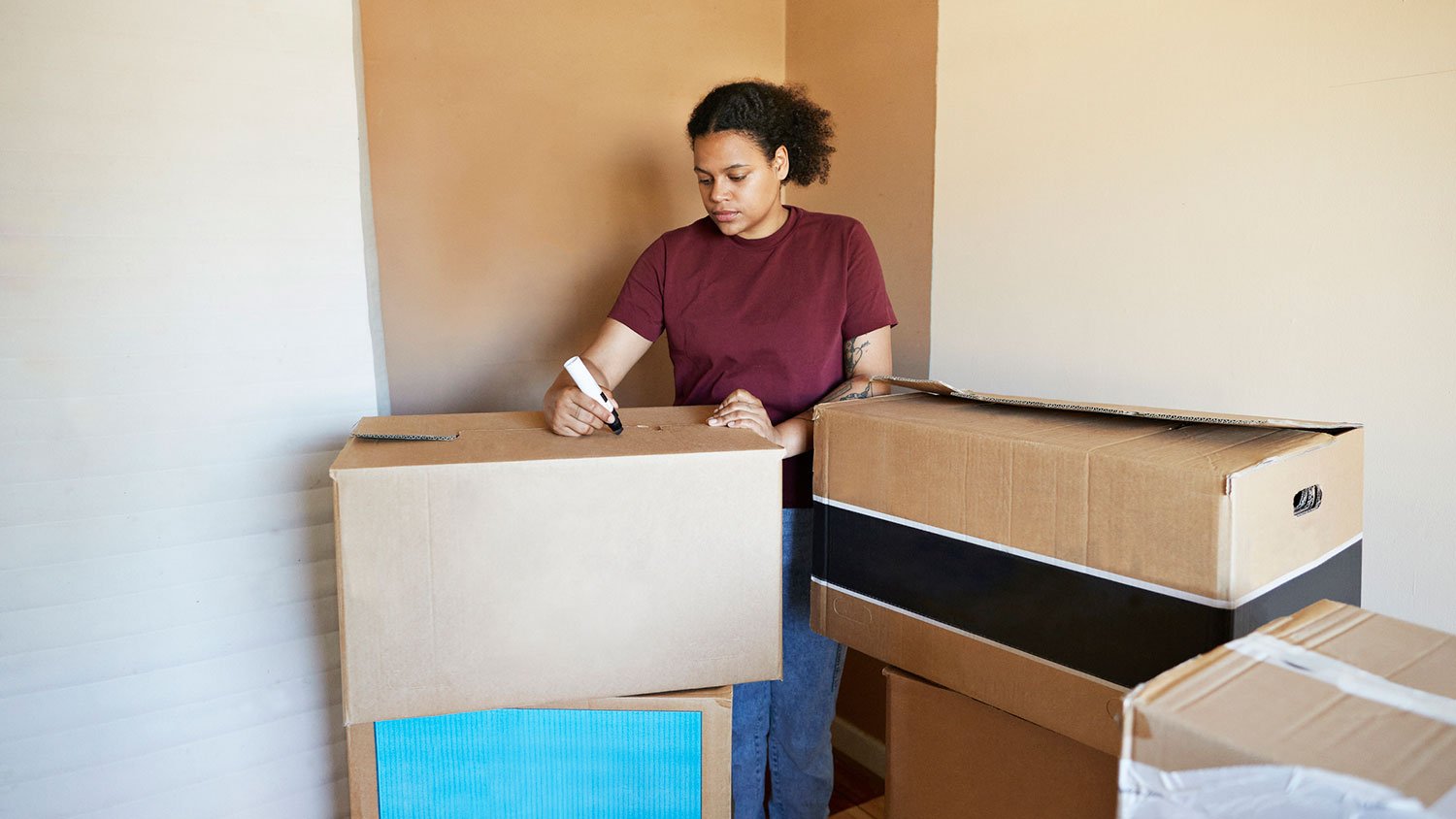 Woman labeling cardboard box with a marker