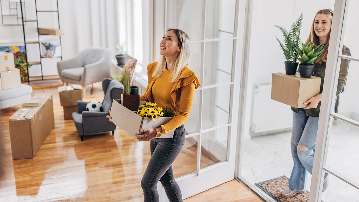 women bring plants into new home 