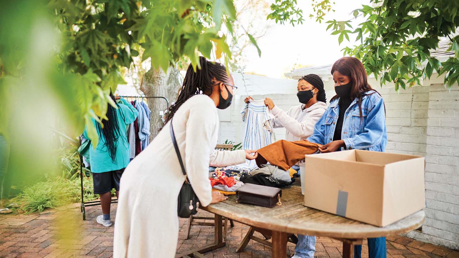 woman in mask buying clothes at garage sale