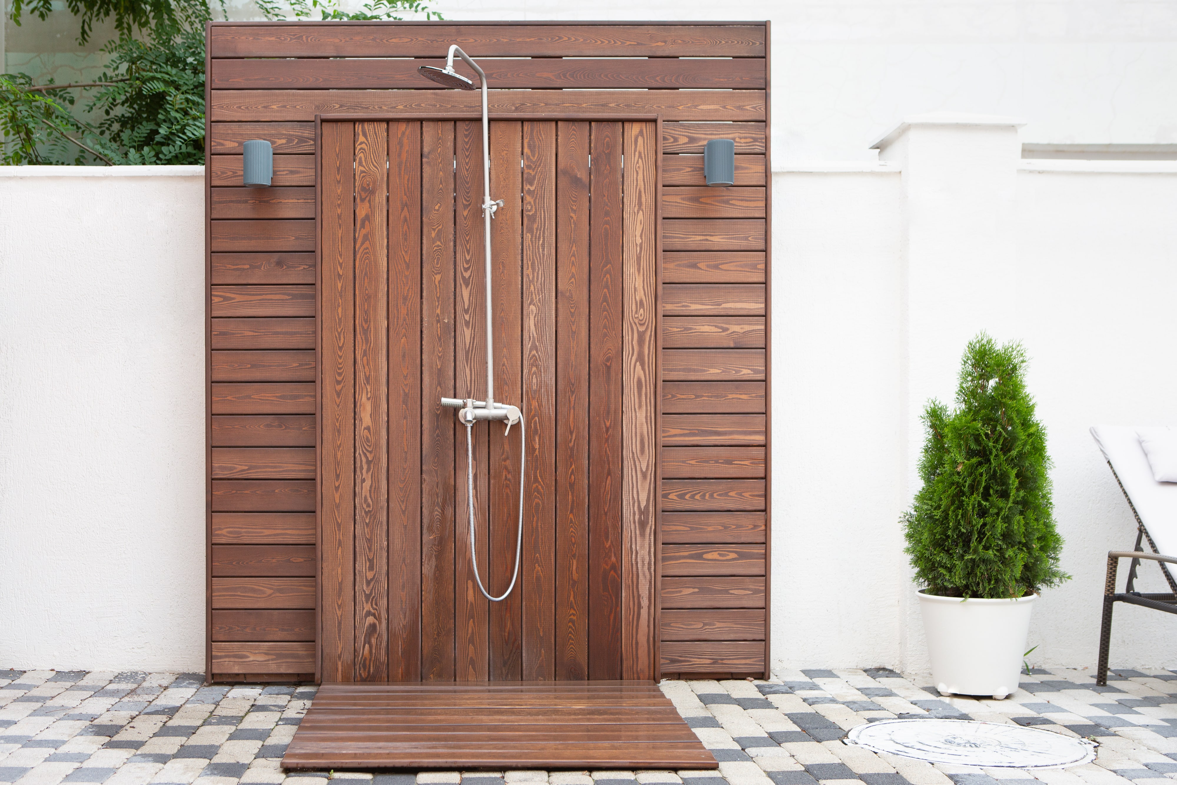 A luxury outdoor shower with wood accents and a rainfall showerhead