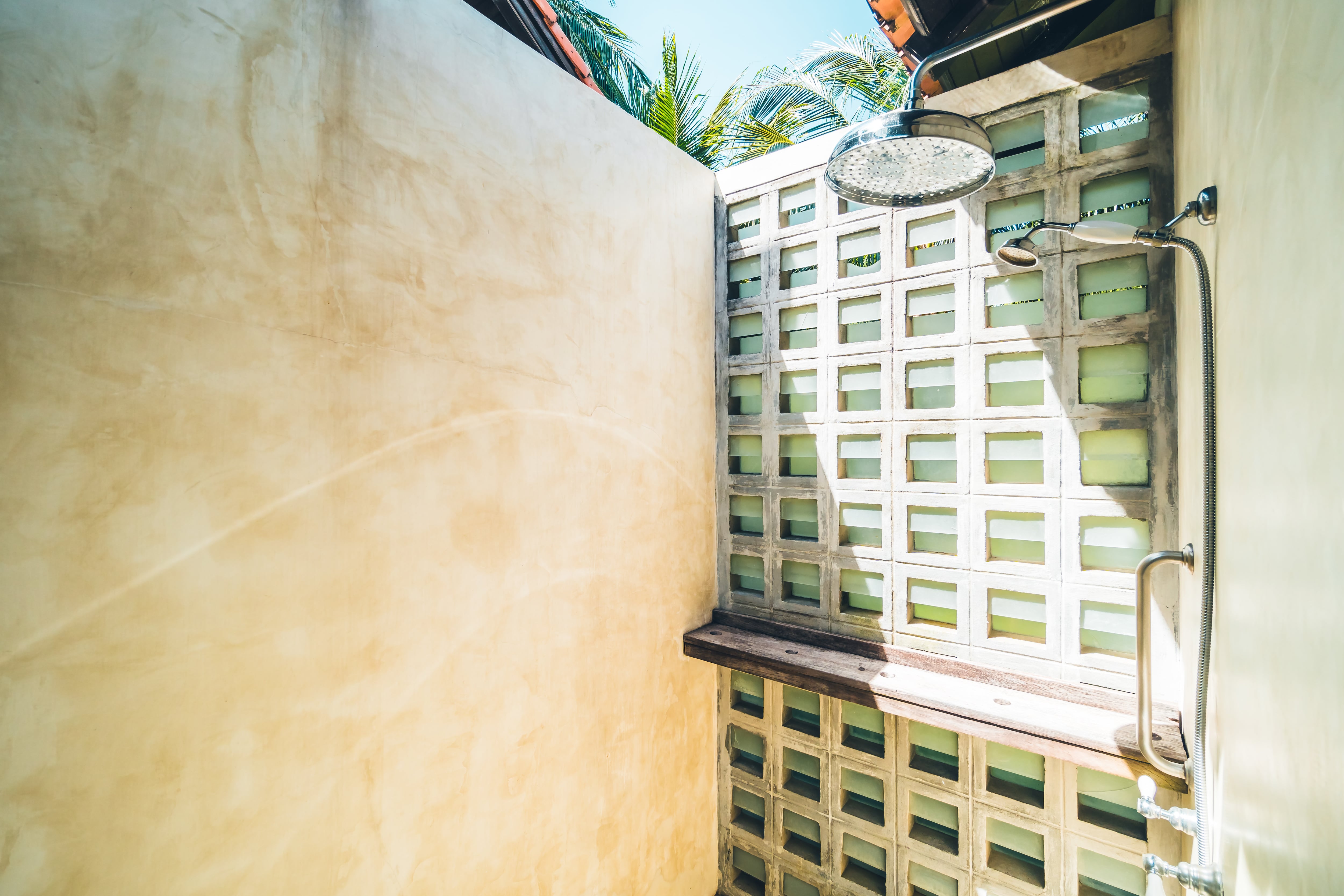 An outdoor shower with a wood shelf