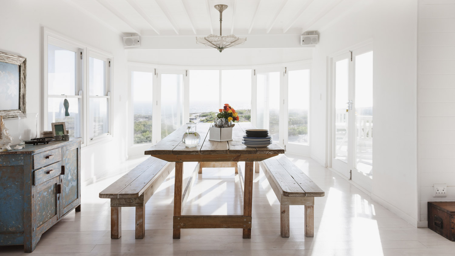 A wooden table and benches in a sunny dining room