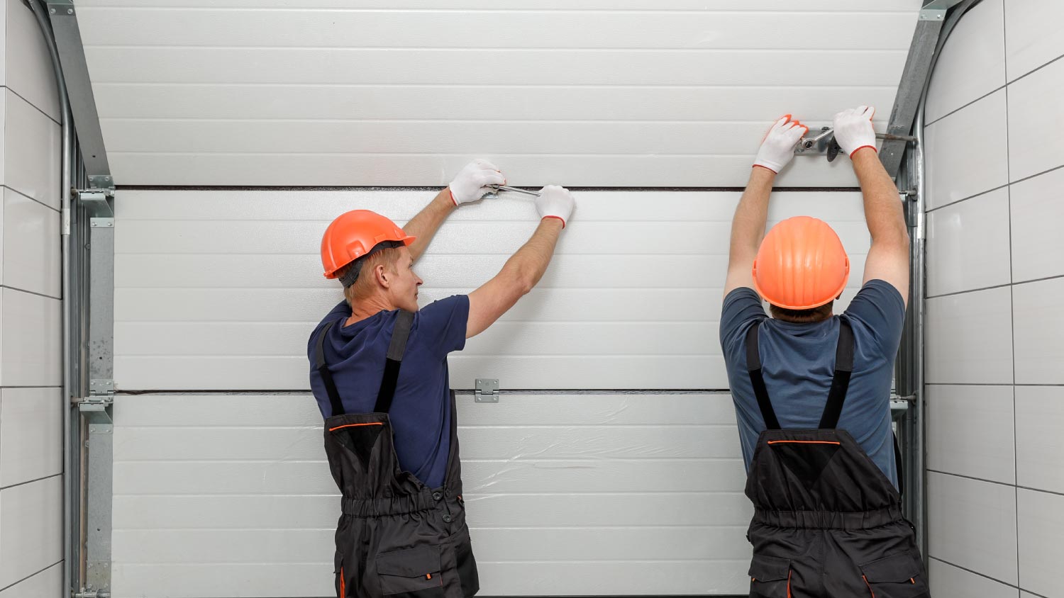 Workers repairing a lifting gates of the garage