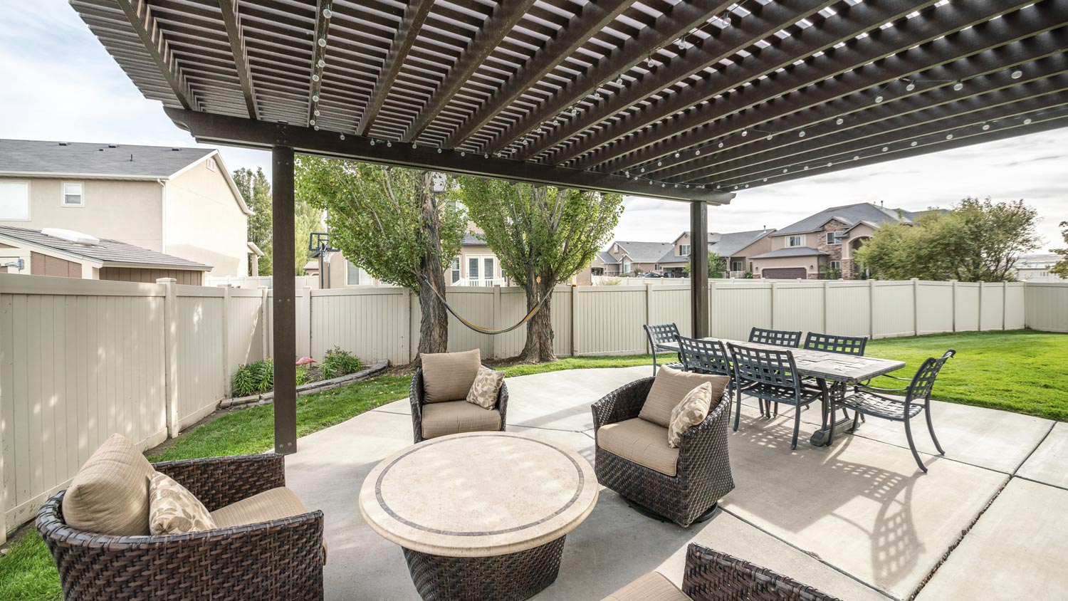 A patio with woven chairs and a roof