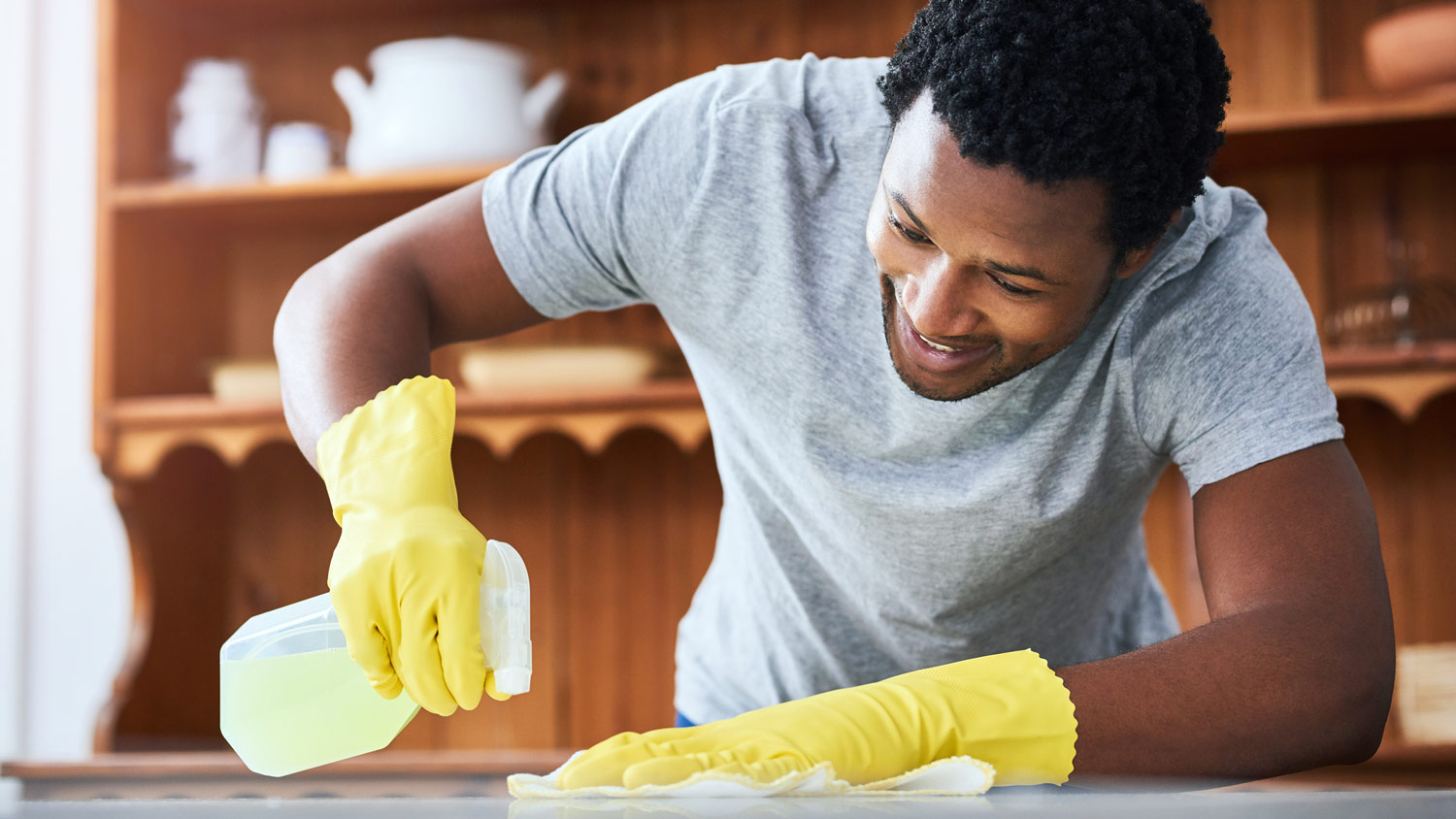 A young man cleaning a kitchen surface