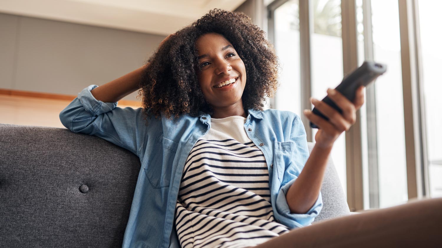 woman using remote watching TV